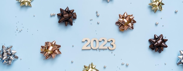 Banner mit Zahlen 2023 auf hellem festlichem Hintergrund mit Schleifen und Perlen Draufsicht Weihnachtshintergrund flach gelegt