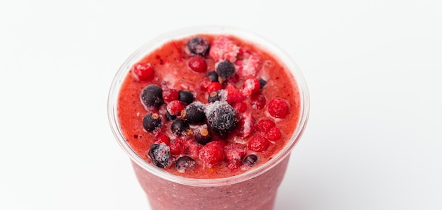 Banner Nahaufnahme eines Beeren-Smoothie mit roten und schwarzen Johannisbeeren an der Spitze