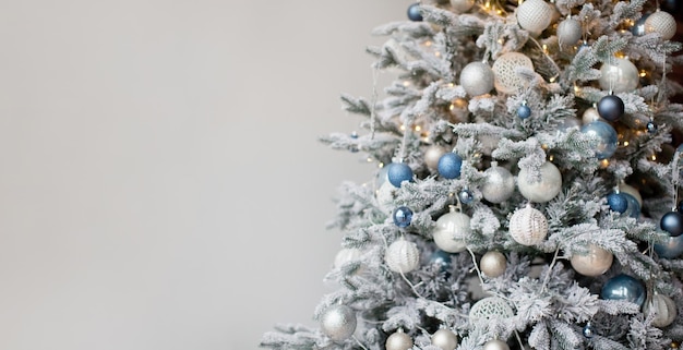 Banner de navidad con árbol de navidad con adornos plateados y azules y luces árbol de navidad sobre un fondo blanco con espacio de copia para texto