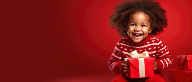 Banner de Navidad Niña afroamericana con un suéter rojo y un regalo en sus manos sobre un fondo rojo liso con espacio para texto