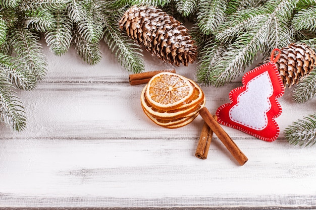Banner navideño con árbol verde, conos, adornos de fieltro hechos a mano, naranja y canela.