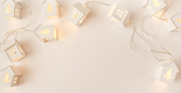 Foto banner navideño invierno año nuevo composición guirnaldas navideñas en forma de casa en beige