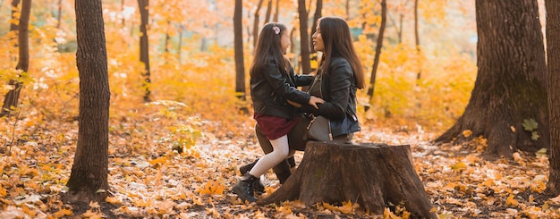 Banner niña jugando con la madre en el espacio de copia del parque de otoño