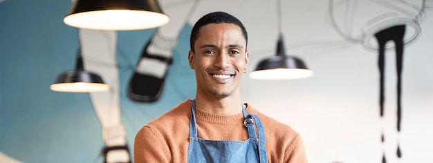 Banner o encabezado horizontal con propietario sonriente o camarero en uniforme de trabajo de pie en una cafetería moderna o restaurante pub Concepto de búsqueda de trabajo Trabajar en catering