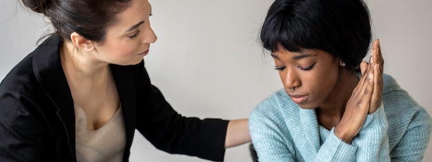 Foto banner o encabezado horizontal con una terapeuta caucásica que brinda ayuda psicológica a una paciente afroamericana que la consuela tratamiento de trastornos emocionales y del estado de ánimo