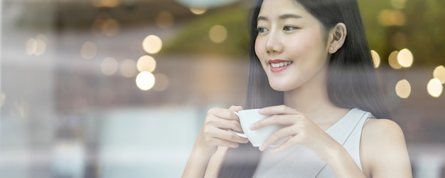 Banner de página web o plantilla de portada de mujeres jóvenes asiáticas sosteniendo una taza de café