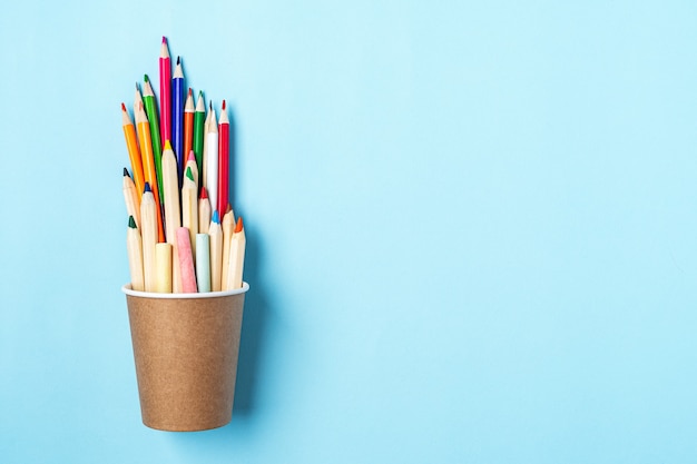 Banner plano de regreso a la escuela con lápiz en una taza de café, útiles escolares y otros artículos de papelería