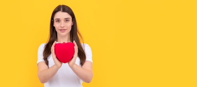 Banner de retrato de cara aislada de mujer con espacio de copia mujer sonriente comparte corazón de amor en camisa blanca sobre fondo amarillo 14 de febrero