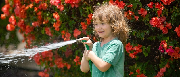 Banner de riego infantil de primavera niño divertido jugando con manguera de jardín en el patio trasero niño divirtiéndose