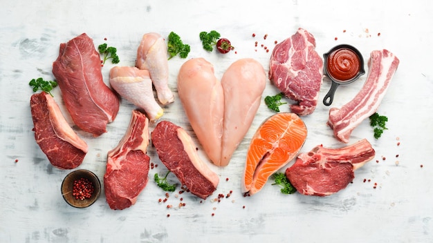 Banner. Rohes Fleisch Steaks Lachs, Rind und Huhn auf weißem Holzhintergrund. Bio-Lebensmittel. Ansicht von oben.