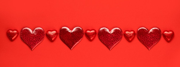 Banner de San Valentín con corazones rojos y chocolate.