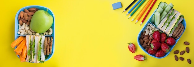 Banner Schulessen in der blauen Box und Schulbriefpapier auf gelbem Hintergrund Draufsicht Kopierbereich