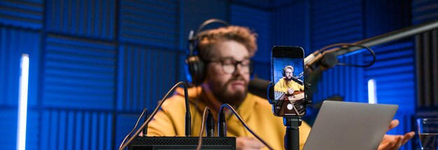 Banner streaming ao vivo com sorridente homem milenar como apresentador de rádio com microfone talk show ou