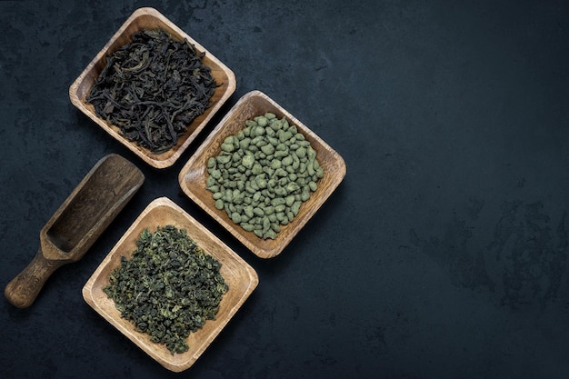 Foto banner de surtido de infusión de té en placas de madera sobre fondo negro té verde infusión té de ginseng