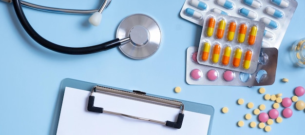 Banner con tableta de pastillas de colores y estetoscopio vista plana superior Concepto de salud y medicina