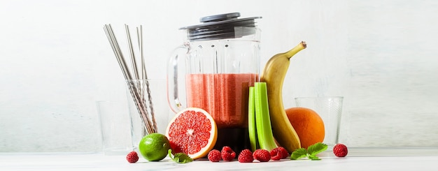 Banner von Smoothies in einer Glasmixerschale und Zutaten auf dem Tisch. Nicht wegwerfbare Metallrohre. Gesundes Essen.