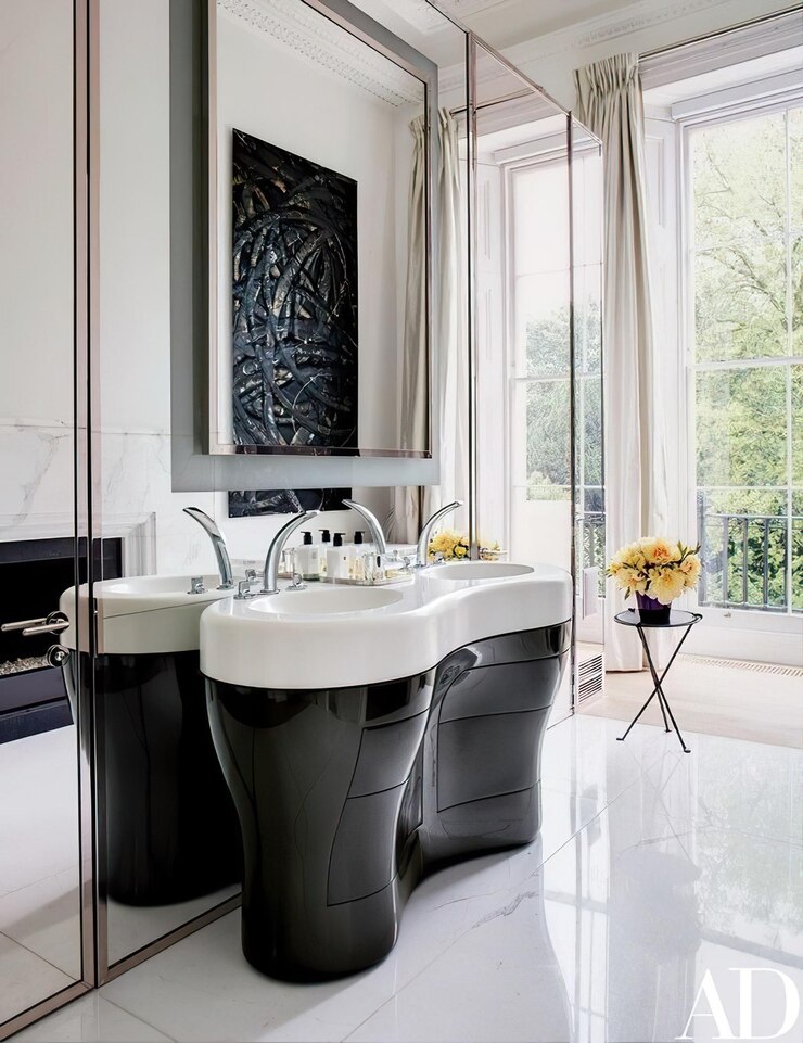 un baño blanco y negro con un fregadero blanco y una imagen de una ventana