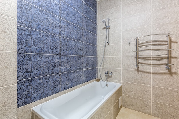 Baño con ducha, bañera y azulejos claros