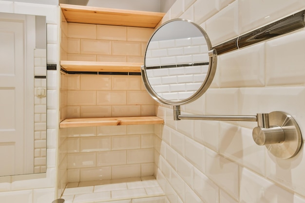 El baño está rodeado de azulejos en forma de ladrillo con espejo y estantes de madera.