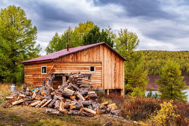 Baño de madera con pila de leña en el lago Uzunkel. Altai, Rusia