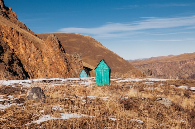 Foto un baño de madera verde en medio de un hermoso paisaje con altas laderas y montañas y árboles verdes en un prado alpino en un claro día de invierno