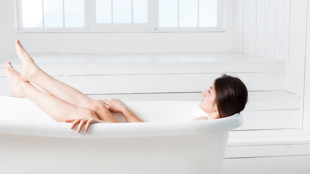 Foto baño de mujer tomando en interior minimalista
