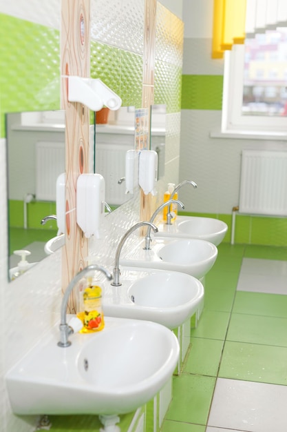 Foto baños para niños con fregaderos blancos y espejo