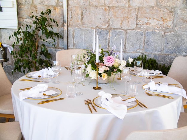 Banquete de bodas concepto sillas y mesa redonda para invitados servidos con cuchillero y flores y crocker