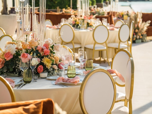 Banquete de bodas concepto sillas y mesa redonda para invitados servidos con cuchillero y flores y crocker