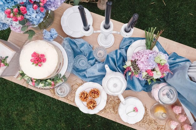 Banquete mesa de postres decorada en estilo rústico decorado con platos cubiertos vasos velas