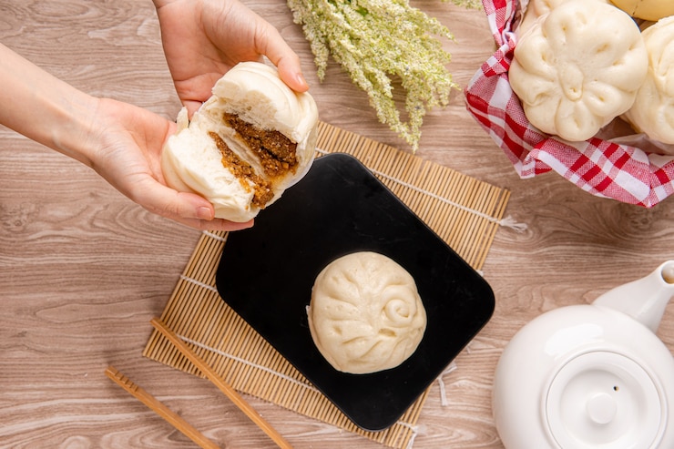 Foto baozi ou bakpao é um tipo de pão de fermento recheado com fermento em várias cozinhas chinesas. existem muitas variações nos recheios de carne ou vegetarianos e preparações, embora os pães sejam na maioria das vezes cozidos no vapor