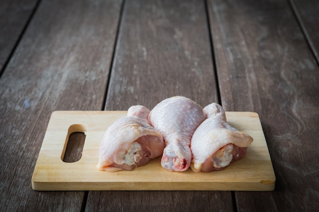 Baqueta de frango e tábua de cortar na mesa de madeira