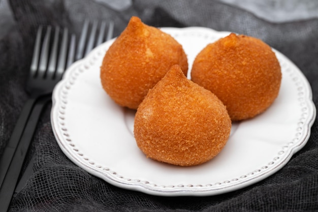 Baquetas fritas brasileñas tradicionales Coxinha de frango en un plato pequeño