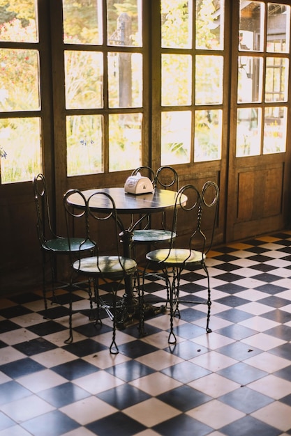 Foto bar elegante, restaurante, móveis antigos e chão quadrado preto e branco.