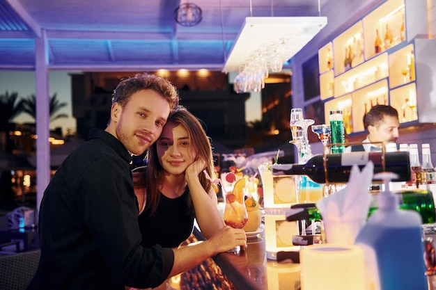 En el bar Feliz pareja joven está junta en sus vacaciones