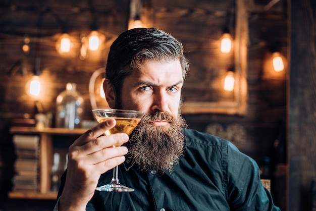 Bar retrô homem barbudo sentado no bar homem bonito bebendo álcool enquanto está sentado no bar