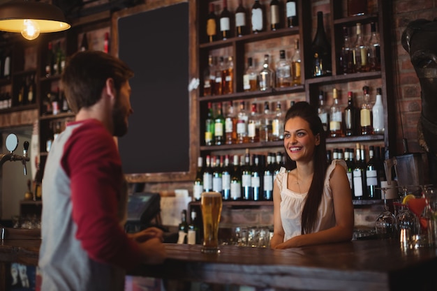 Bar tender feminino interagindo com o cliente