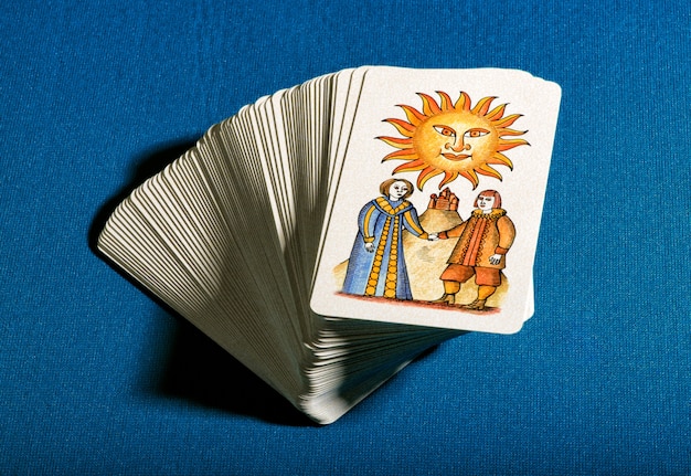 Baralho de cartas de tarô empilhadas com o sol por cima