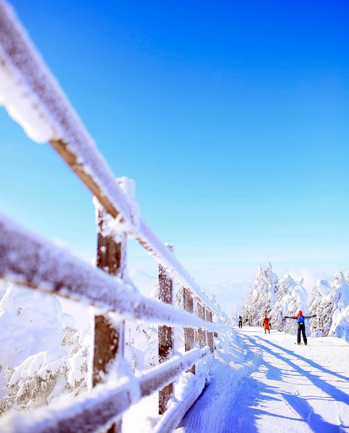 Foto barandilla cubierta de nieve contra el cielo azul