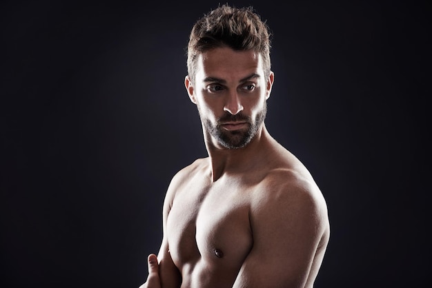 La barba es siempre una bonificación Foto de estudio de un hombre guapo de pie sin camisa contra un fondo negro