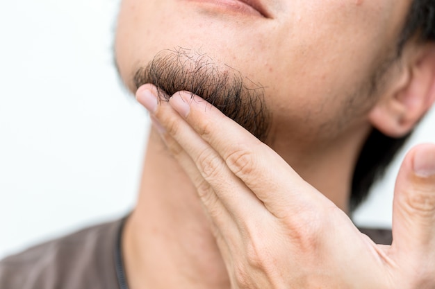 Barba de los hombres del primer con la mano que toca el pelo negro en la barbilla