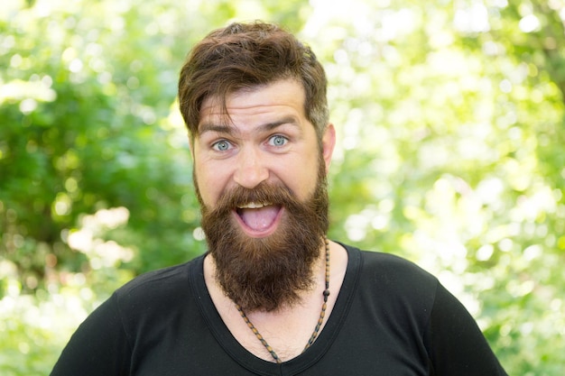 La barba con profundidad y textura. Hombre barbudo sonriendo con elegante forma de bigote y barba. Hipster sin afeitar con pelo de barba con textura en verano al aire libre. Chico caucásico feliz con barba en la naturaleza.