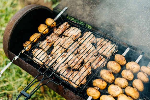 Barbacoa con carne y champiñones fritos a la parrilla al aire libre en el patio trasero setas en brochetas son