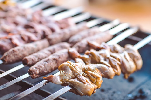 Barbacoa de diferentes tipos de carne en el restaurante en el fondo de los invitados.