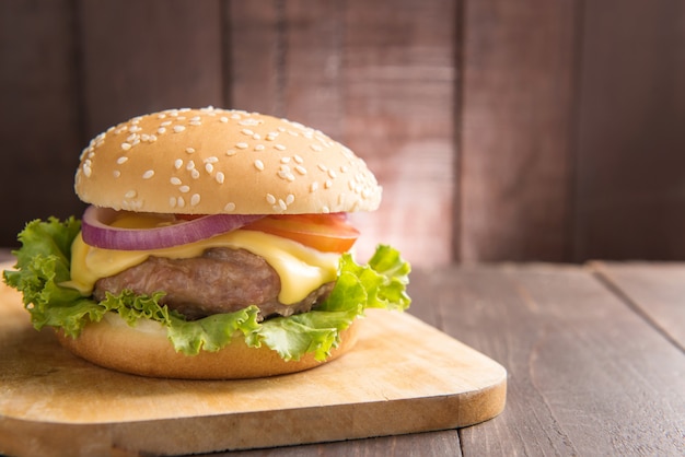 Barbacoa hamburguesas en tabla de cortar en mesa de madera.