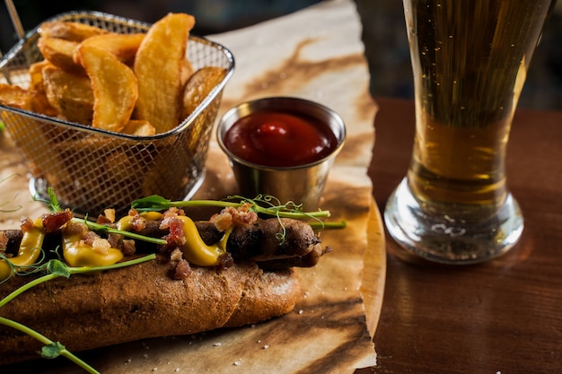 Barbacoa de hot dog a la parrilla y cerveza con mostaza amarilla y salsa de tomate