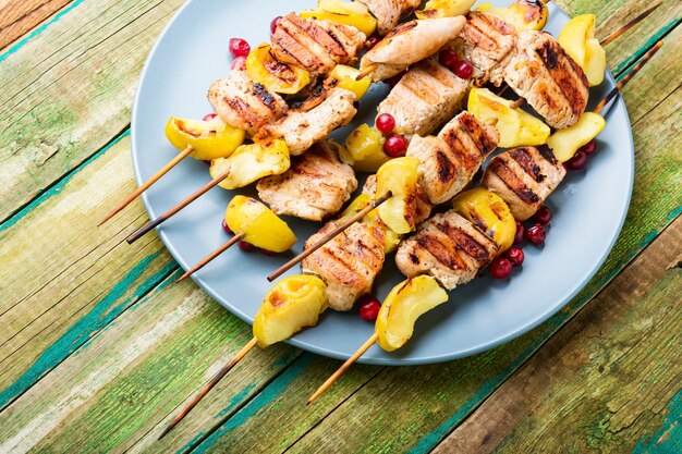 Barbacoa de pavo shish kebab con manzana en la mesa de madera rural