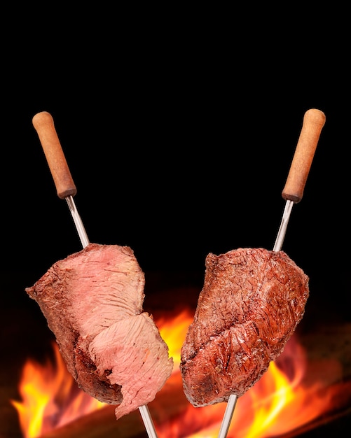 Barbacoa Picanha asada con fuego borroso en el fondo También llamado churrasco