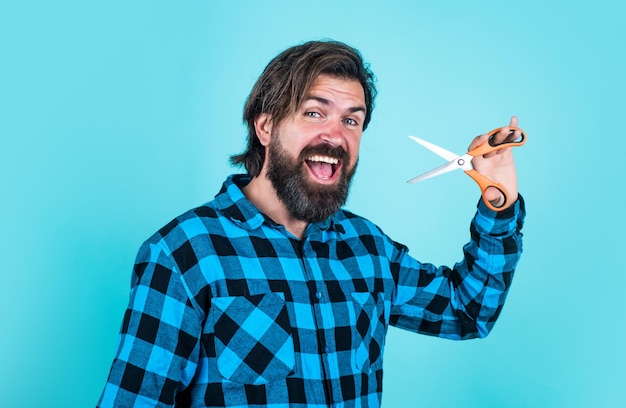 Barbearia conceito homem barbudo em camisa quadriculada cortar cabelo cara casual usar ferramenta de barbeiro feliz hipster com cabelos longos e bigode segurar tesoura beleza masculina e moda