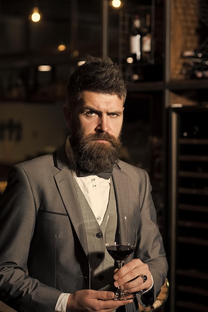 Barbearia estilo de cabelo copo de vinho perfeito nas mãos de homem barbudo sério em terno formal